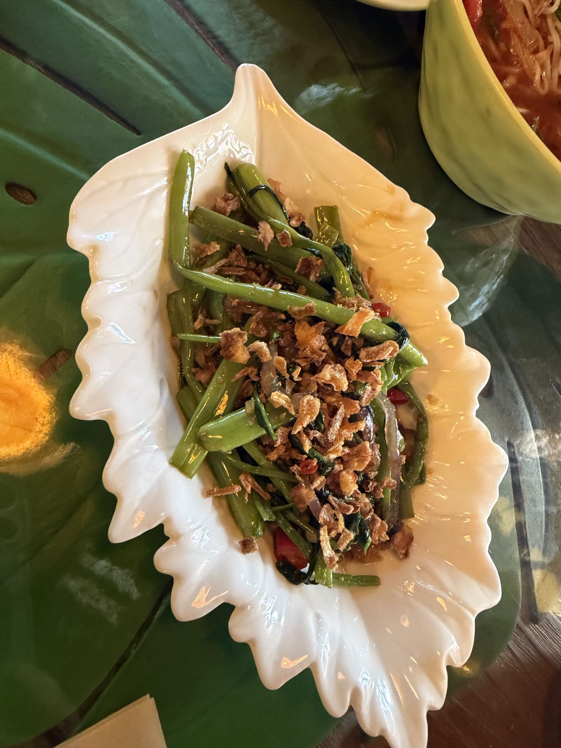 Stir-fried morning glory on a leaf-shaped plate
